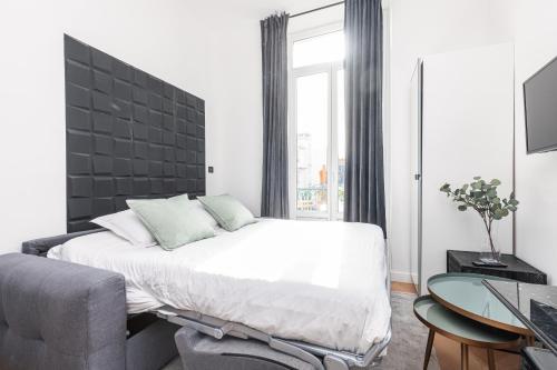 une chambre avec un lit, une chaise et un bureau dans l'établissement 7 FOCH 202 - Studio contemporain en plein coeur de Nice - climatisation, à Nice