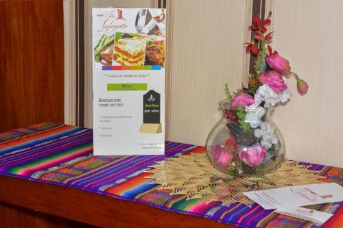 a vase filled with flowers sitting on a table at Hotel Villa Lafayette in Quito