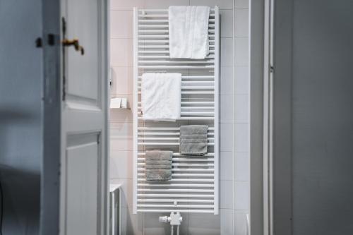 a bathroom with white towels on a towel rack at Hotel Les Eleveurs in Halle