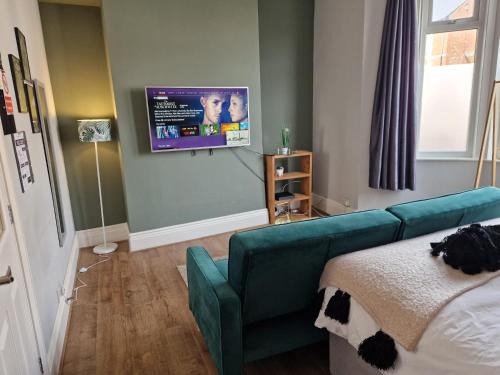 a living room with a couch and a flat screen tv at West Beck House Newcastle - Spacious Double Room in Newcastle upon Tyne