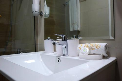 a bathroom sink with a faucet and towels on it at Warmcloud 2BR Oasis Home in Masdar - Relaxing Stay Near Masdar Park & City Centre in Abu Dhabi