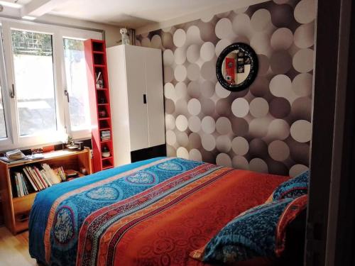 une chambre avec un lit et un miroir au mur dans l'établissement Jolie maison, 3 chambres, jardin et parking, à Bagneux