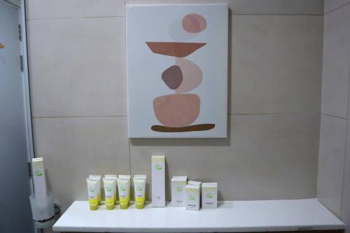 a bathroom with a white counter with a painting on the wall at Calm Oasis 2BR Apartment Masdar City in Abu Dhabi