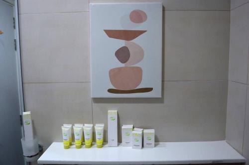 a bathroom with a white counter with a painting on the wall at Warmcloud 2BR Oasis Home in Masdar - Relaxing Stay Near Masdar Park & City Centre in Abu Dhabi