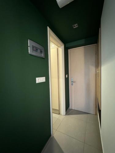 an empty hallway with a green wall and a door at Catherine Hotel in Kos Town