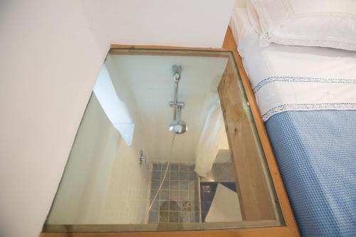 a shower in a room next to a bed at La Cantina - ACrapa Mangia in Santa Maria di Castellabate