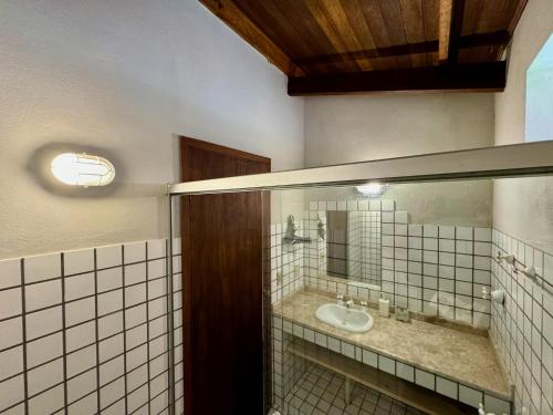 a bathroom with a sink and a mirror at Pousada Chalés Jardim das Bromélias - Visconde de Mauá in Visconde De Maua