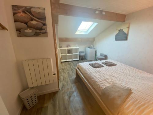 a small bedroom with a bed and a window at Aux Lacs et Cascades in Songeson