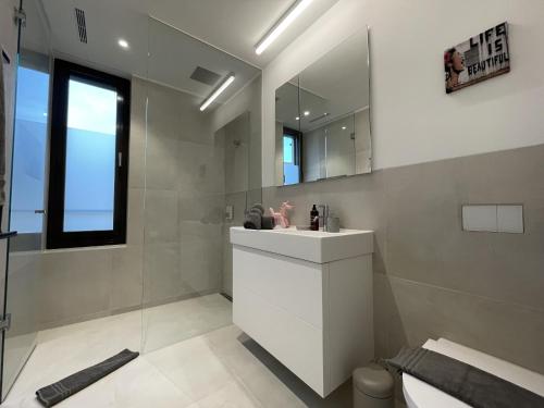 a bathroom with a white sink and a mirror at Cosmopolitan Apartments Rosengartenstrasse in Zürich