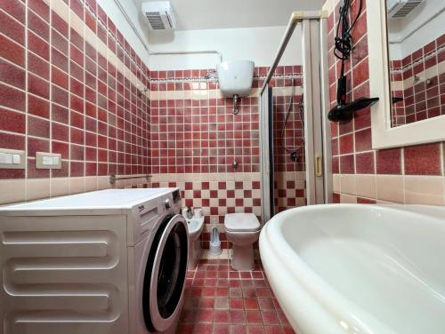 ein Badezimmer mit einem WC, einer Badewanne und einer Waschmaschine in der Unterkunft Oikia Vacanze S Cesarea Casa Rosa su in Santa Cesarea Terme
