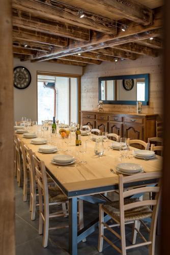 une longue table avec des chaises et une grande table avec des verres dans l'établissement Chalet montagnard rénové avec jacuzzi 4****- 15 Personnes, à Saint-Sorlin-dʼArves