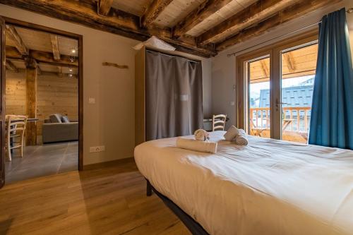 a bedroom with a large bed with towels on it at Chalet montagnard rénové avec jacuzzi 4****- 15 Personnes in Saint-Sorlin-dʼArves