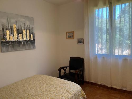 a bedroom with a bed and a window and a chair at Casa Minnana in Figari