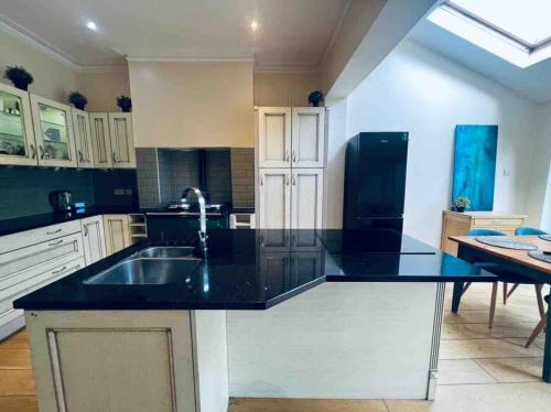 a kitchen with a black counter top and a sink at Cricklewood Boutique Stay in London