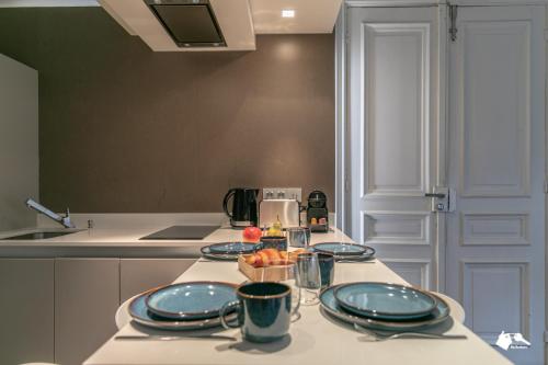 eine Küche mit einem Tisch mit Tellern und einer Obstschale in der Unterkunft MBA - Luxury Berthier Proche des Ternes in Paris