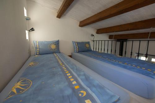 two beds in a room with blue pillows at La Rimessa - ACrapa Mangia in Santa Maria di Castellabate