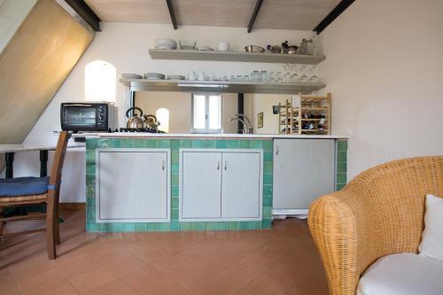 a kitchen with green and white tile on the counters at La Rimessa - ACrapa Mangia in Santa Maria di Castellabate