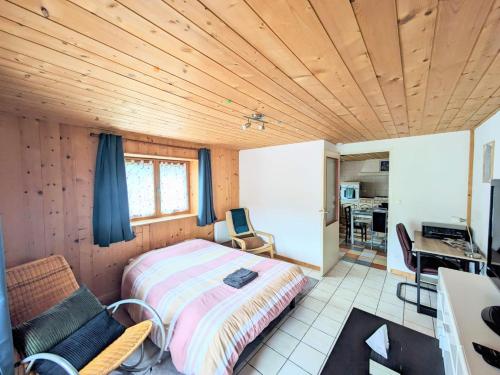 a bedroom with a bed and a desk and a kitchen at appart proche de la nature in Les Gras