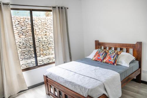 a bedroom with a bed and a large window at Canavida Villas & Resort in Uvita