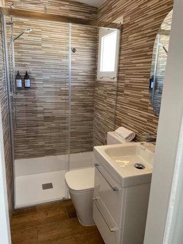 a bathroom with a shower and a toilet and a sink at El Escondido de Zahara in Zahara de los Atunes