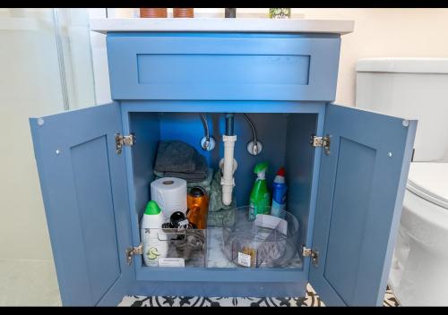 um armário azul cheio de itens numa casa de banho em Chic Naples cottage 7 min from the beach em Naples