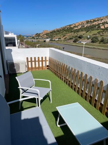 a balcony with chairs and a table and a view of the ocean at El Escondido de Zahara in Zahara de los Atunes