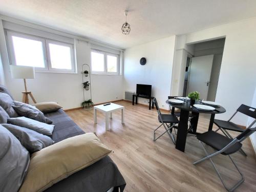 - un salon avec un canapé et une table dans l'établissement St-Quentin-en-Yvelines Plusieurs appartements avec parking, à Trappes