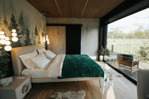 a bedroom with a bed and a large window at Porumbacu Garden in Porumbacu de Sus