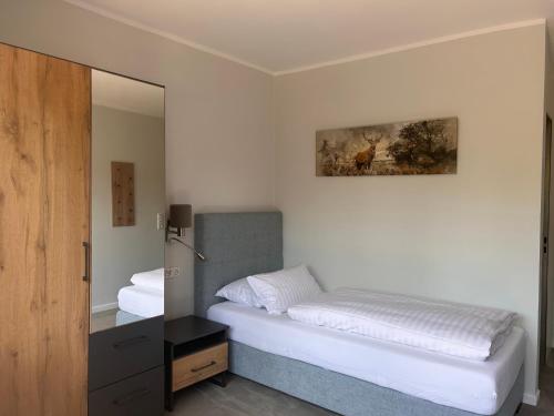 a bedroom with a bed and a mirror at Hotel Haus am Hochwald in Hahnenklee-Bockswiese