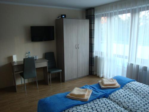 a bedroom with a bed with two towels on it at Willa Alwa in Iława