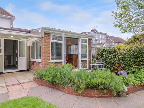 a brick house with a conservatory and some plants at The Annex in Colchester