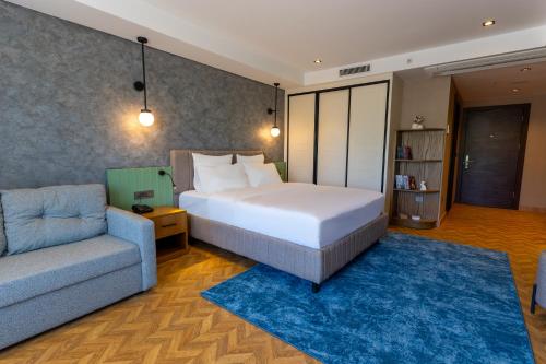 ein Schlafzimmer mit einem großen Bett und einer Couch in der Unterkunft Q Style Hotel in Pelitli