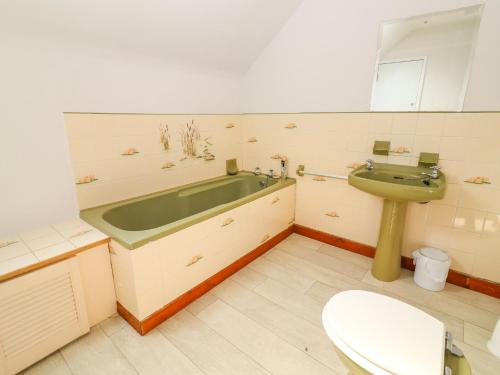 ein Badezimmer mit einer Badewanne, einem Waschbecken und einem WC in der Unterkunft Tonakilla House in Camp