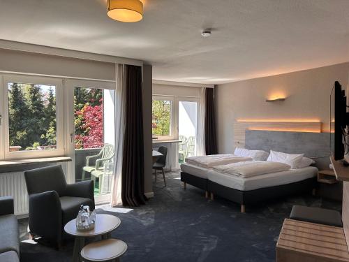 een slaapkamer met een bed en een woonkamer bij Hotel Haus am Hochwald in Hahnenklee-Bockswiese