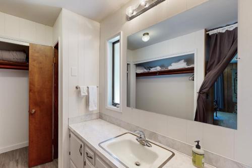 ein Bad mit einem Waschbecken und einem Spiegel in der Unterkunft Davis House on the Bay in Lopez