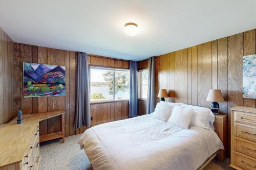 1 dormitorio con cama, escritorio y ventana en Davis House on the Bay, en Lopez