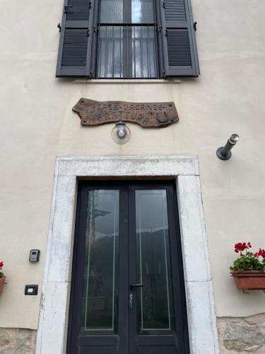 een gebouw met een deur en een bord erop bij Casa Vacanze Frattura in Frattura