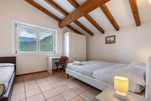 een slaapkamer met een bed, een bureau en een raam bij Tanas in Tenno