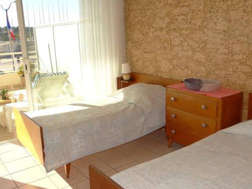 une chambre avec deux lits et une commode et une fenêtre dans l'établissement Grand T3 avec terrasse et piscine à Cavalaire-sur-Mer - FR-1-100-187, à Cavalaire-sur-Mer