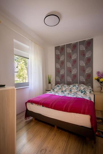 a bedroom with a large bed with a purple bedspread at Apartman Milka in Slunj