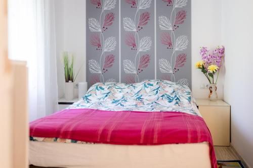 a bedroom with a bed with a pink comforter at Apartman Milka in Slunj