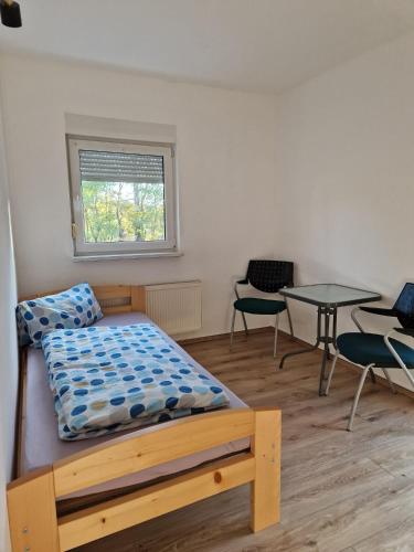 1 dormitorio con 1 cama, mesa y sillas en Fewo für Monteure 25km bis Berlin, en Mittenwalde