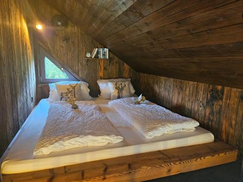 a bedroom with two beds in a wooden cabin at Baumhaus Heuhütte in Salem