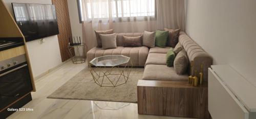 a living room with a couch and a table at Cosy & Confort Studio près de l'aéroport in Nouaceur