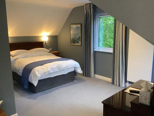 Gleann Fia Country House في كيلارني: غرفة نوم بسرير كبير ونافذة