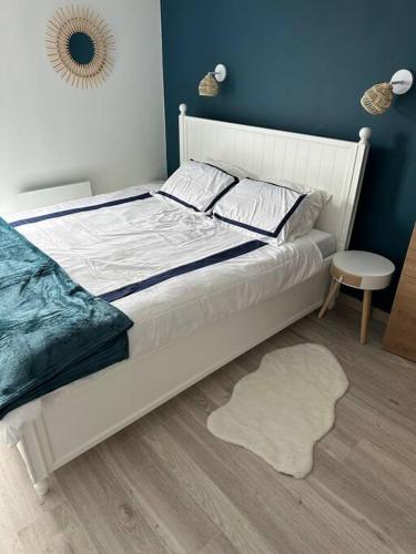 - une chambre avec un lit blanc et un tapis blanc dans l'établissement Appart 4 pers plage vue mer, à Calais
