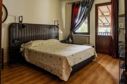 ein Schlafzimmer mit einem großen Bett und Holzboden in der Unterkunft Manuela Le Quattro Coppe in Desenzano del Garda