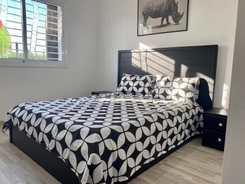 - une chambre avec un lit et une couette noire et blanche dans l'établissement Appartement Urbaine, refuge et Cosy, à Oued Laou