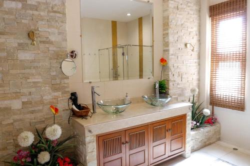 a bathroom with two bowl sinks on a stone wall at November T Pool Villa 2 in Jomtien Beach