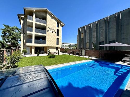a swimming pool in front of a building at Villa Moste 5 -with pool&parking in Ljubljana